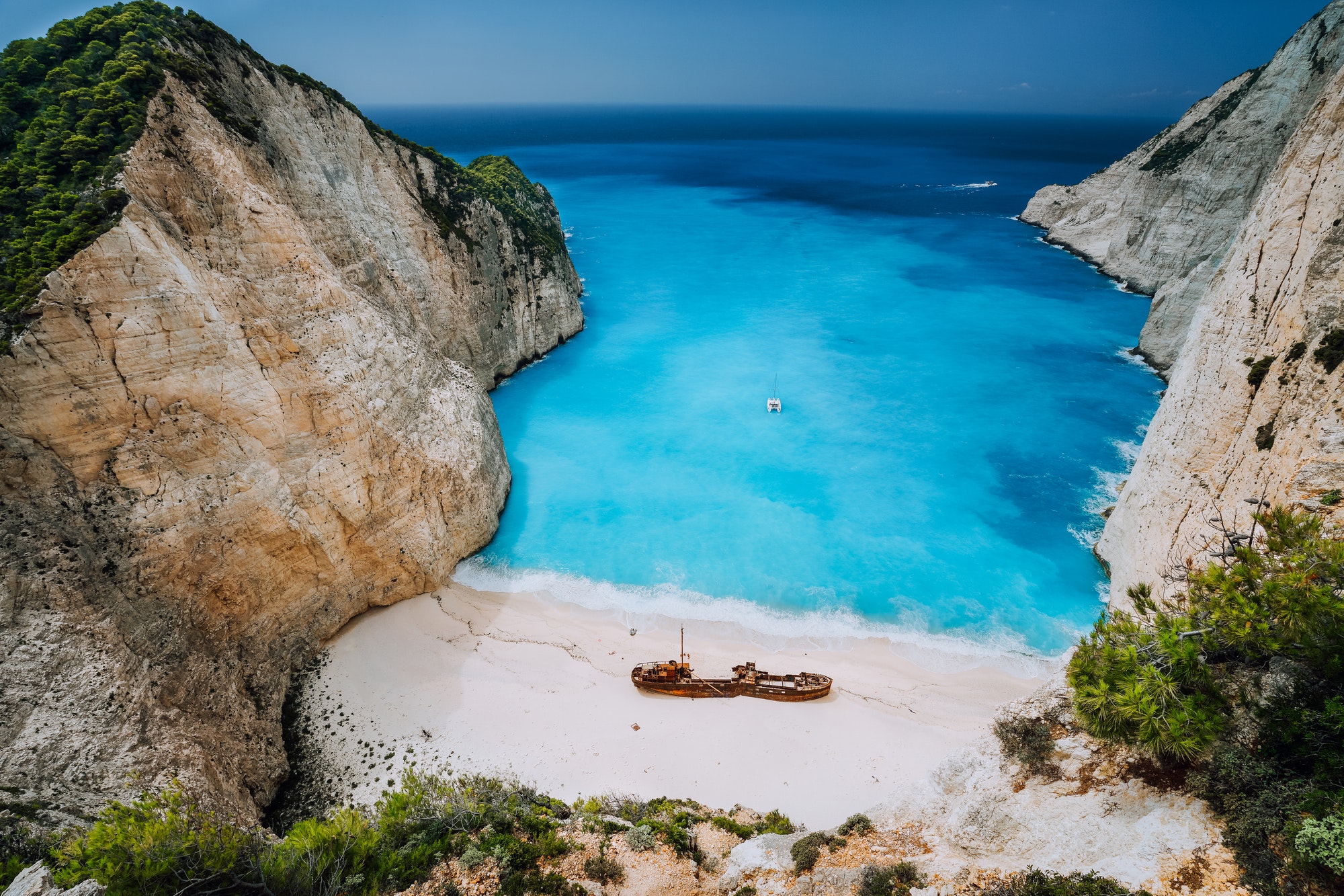 Epic view of Shipwreck middle of sandy Navagio beach surrounded by azure deep turquoise sea